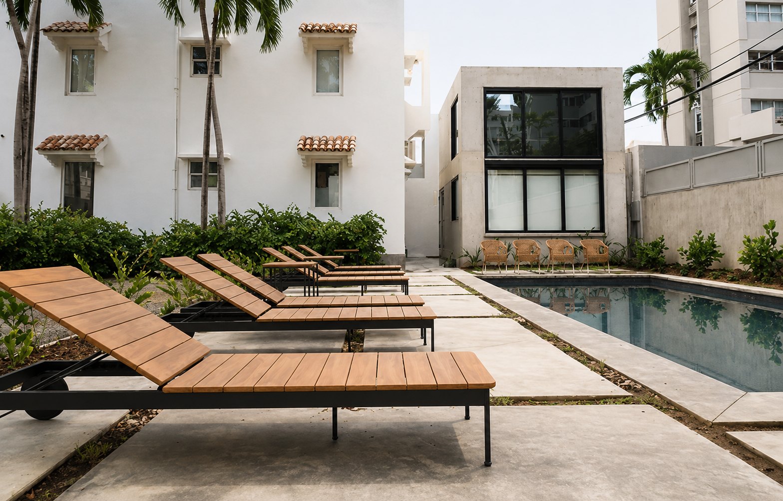 The pool court — pool and teak loungers beside the concrete townhouse