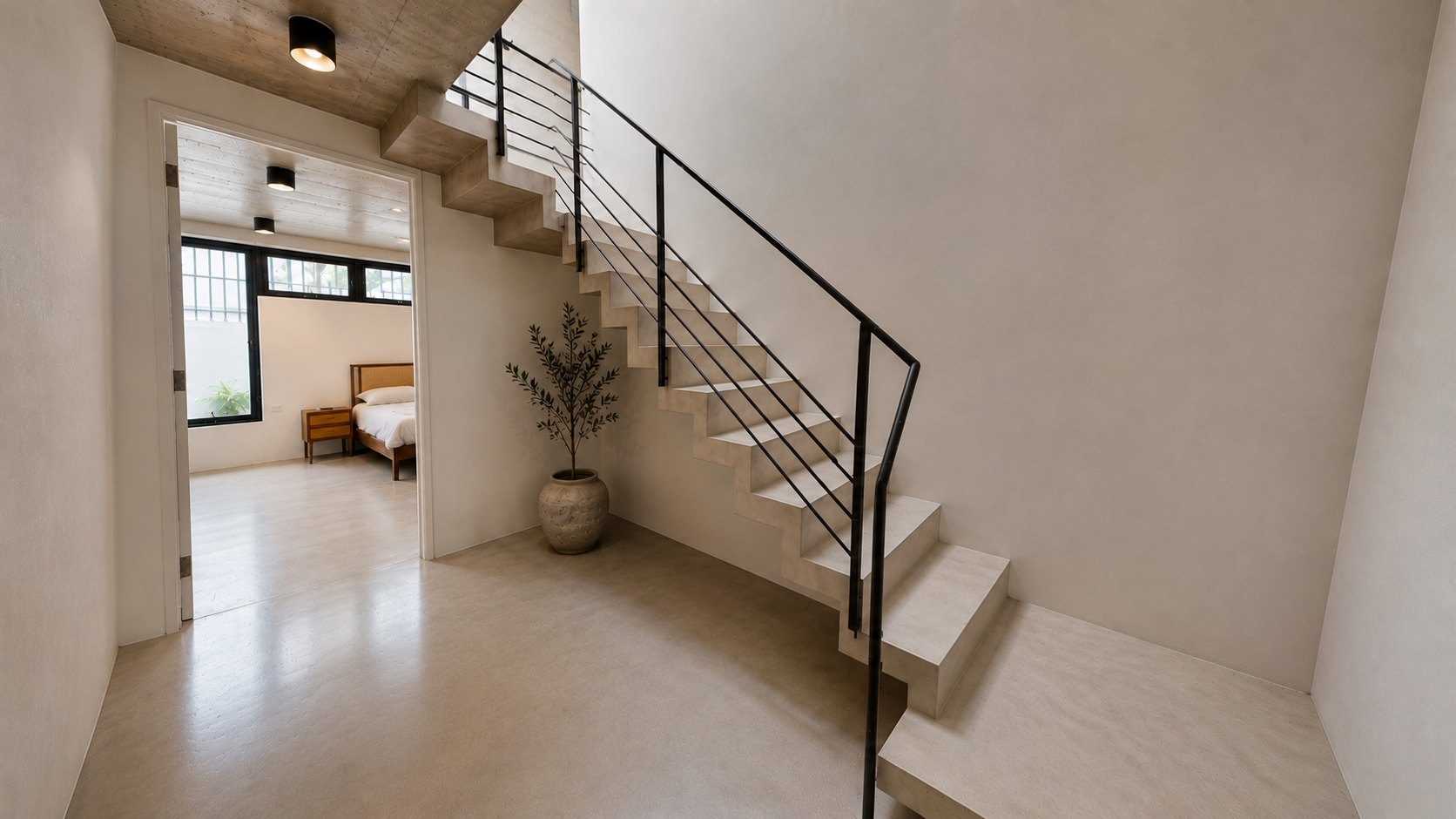 Board-formed concrete stair with black steel rail, olive tree and bedroom beyond